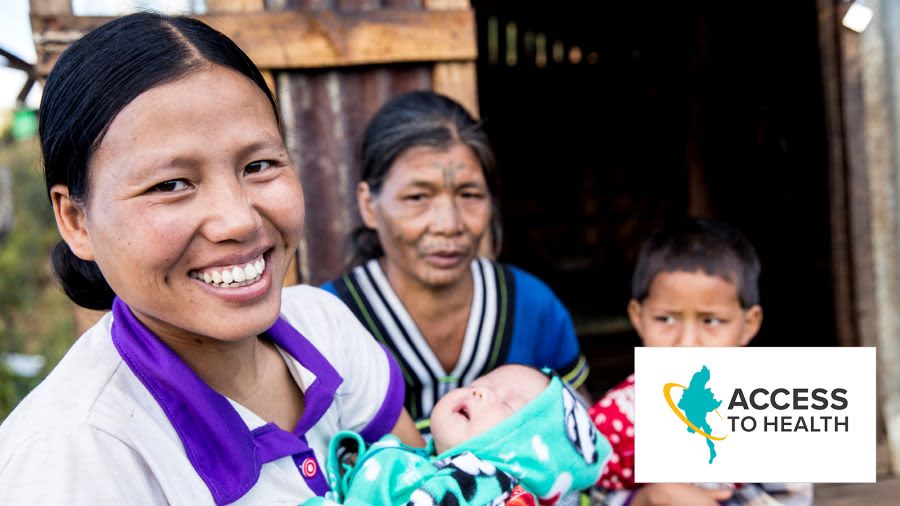 smiling women carrying a baby, in the back another women and a child