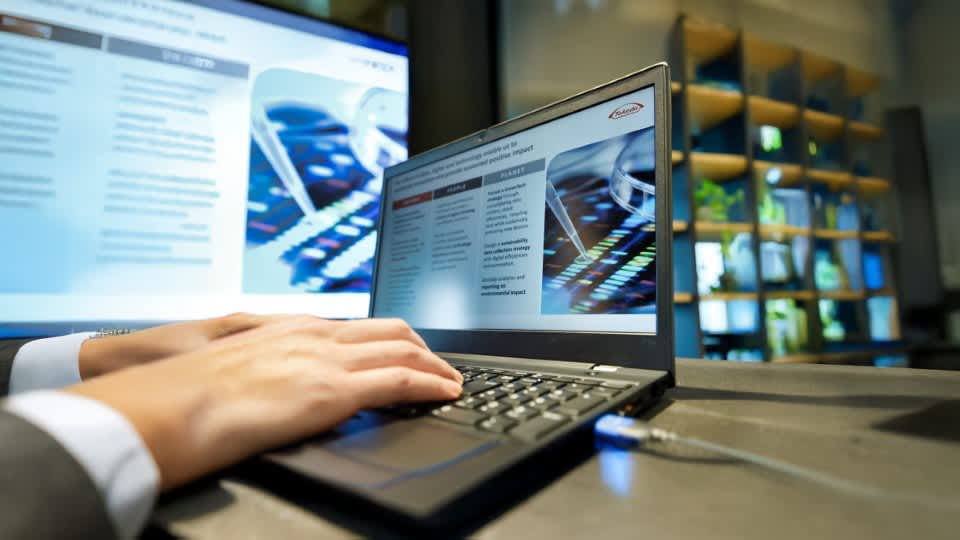 手でパソコンを操作している