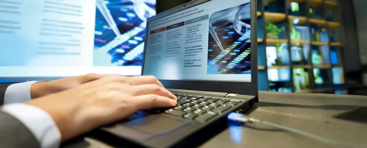 手でパソコンを操作している