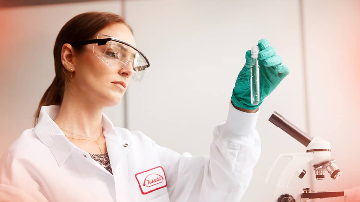 Woman looking at vile in laboratory