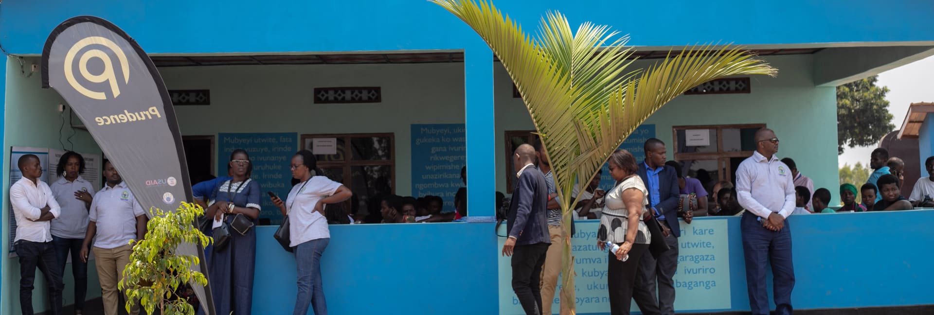 People gathered outside a blue health post building