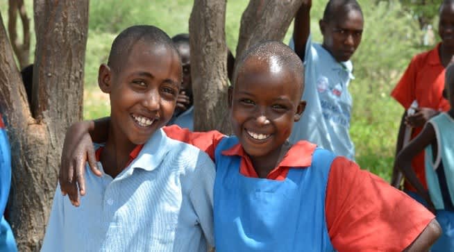 Children standing together in a rural community in Kenya or Somalia, representing communities supported through improved access to healthcare and medicines.