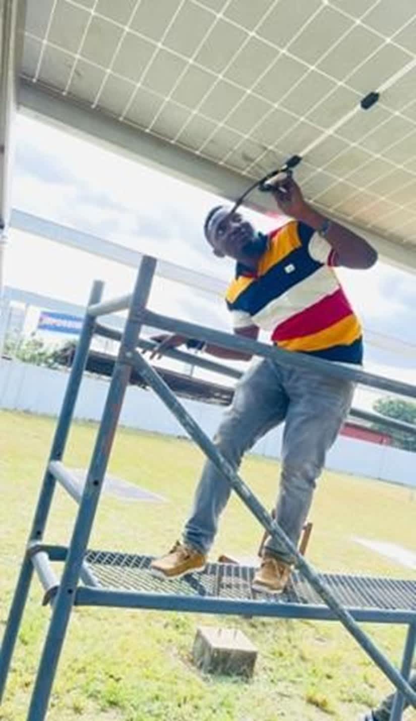 A trained technician installing or maintaining a solar energy system at a hospital to ensure stable electricity supply.