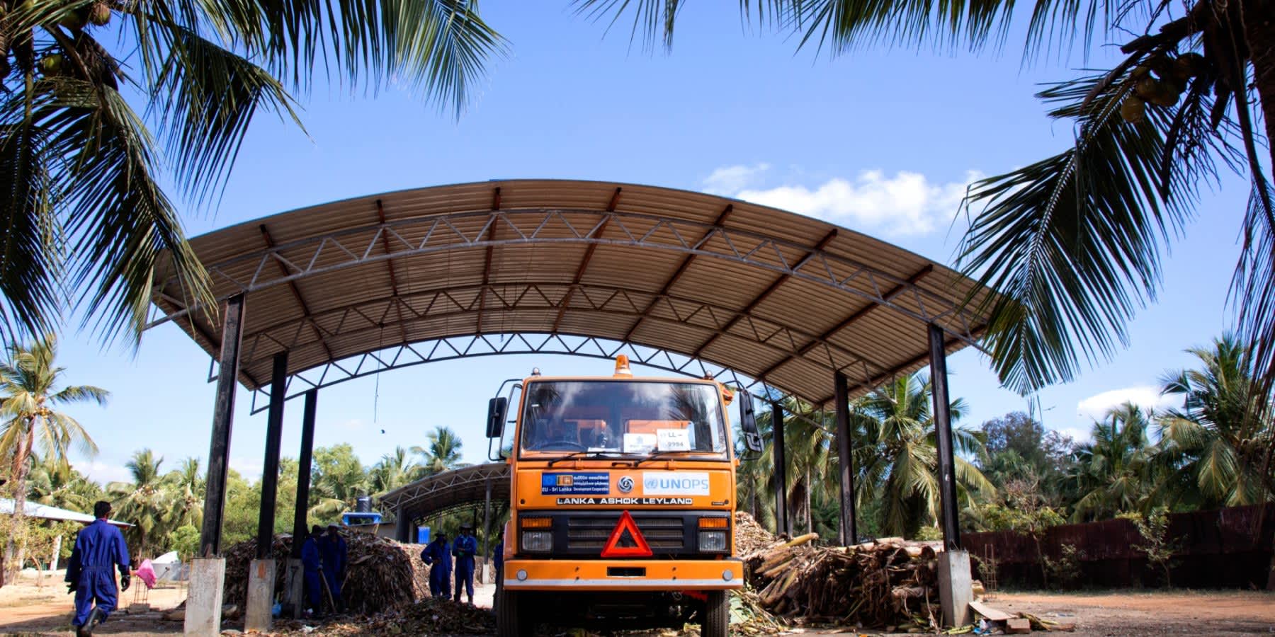 A medical waste collection truck at a covered facility in Bangladesh, representing climate-resilient healthcare waste management infrastructure.