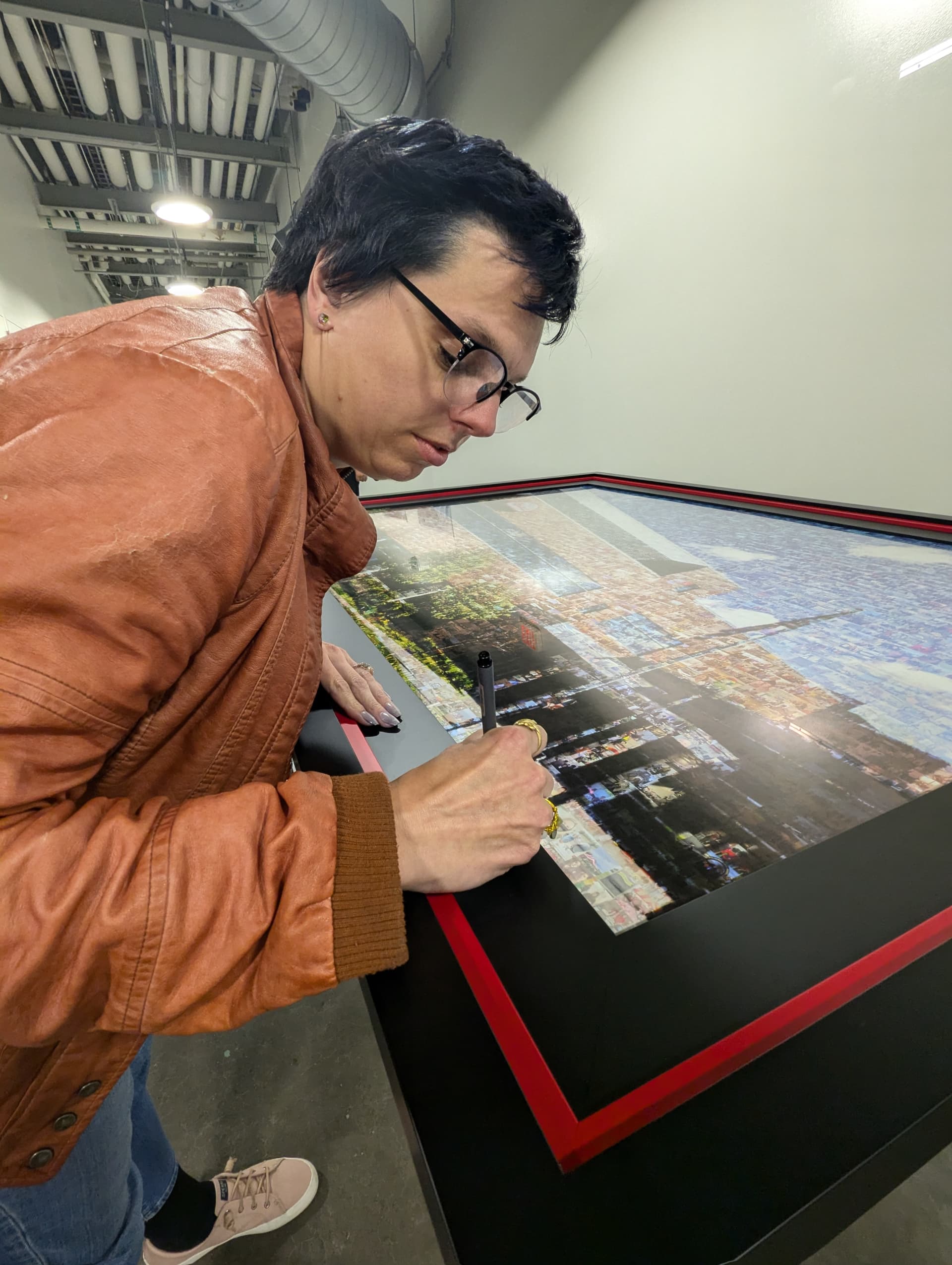 Jennina signing the finished mural at the unveiling event.