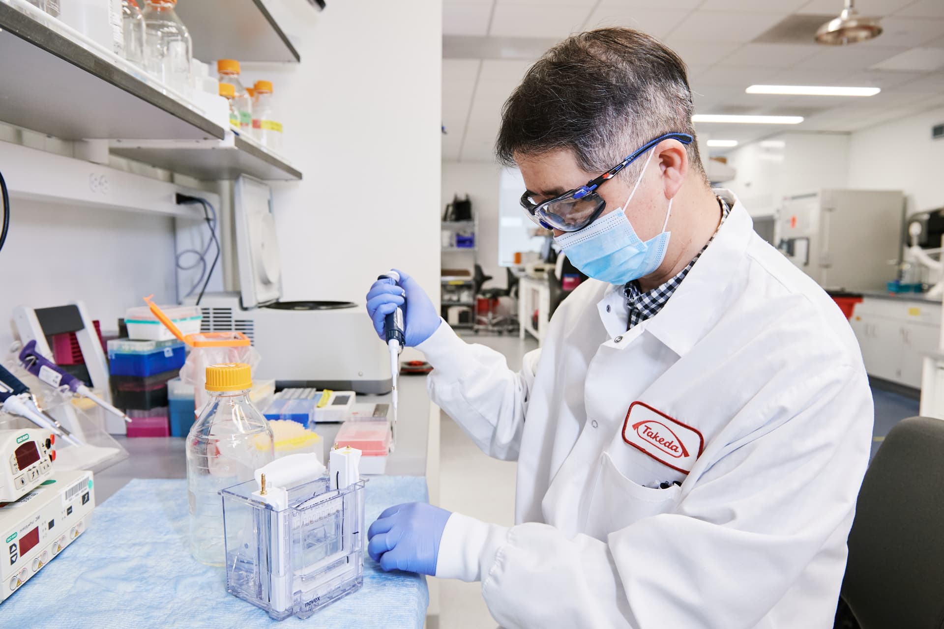 A person in a lab coat and mask