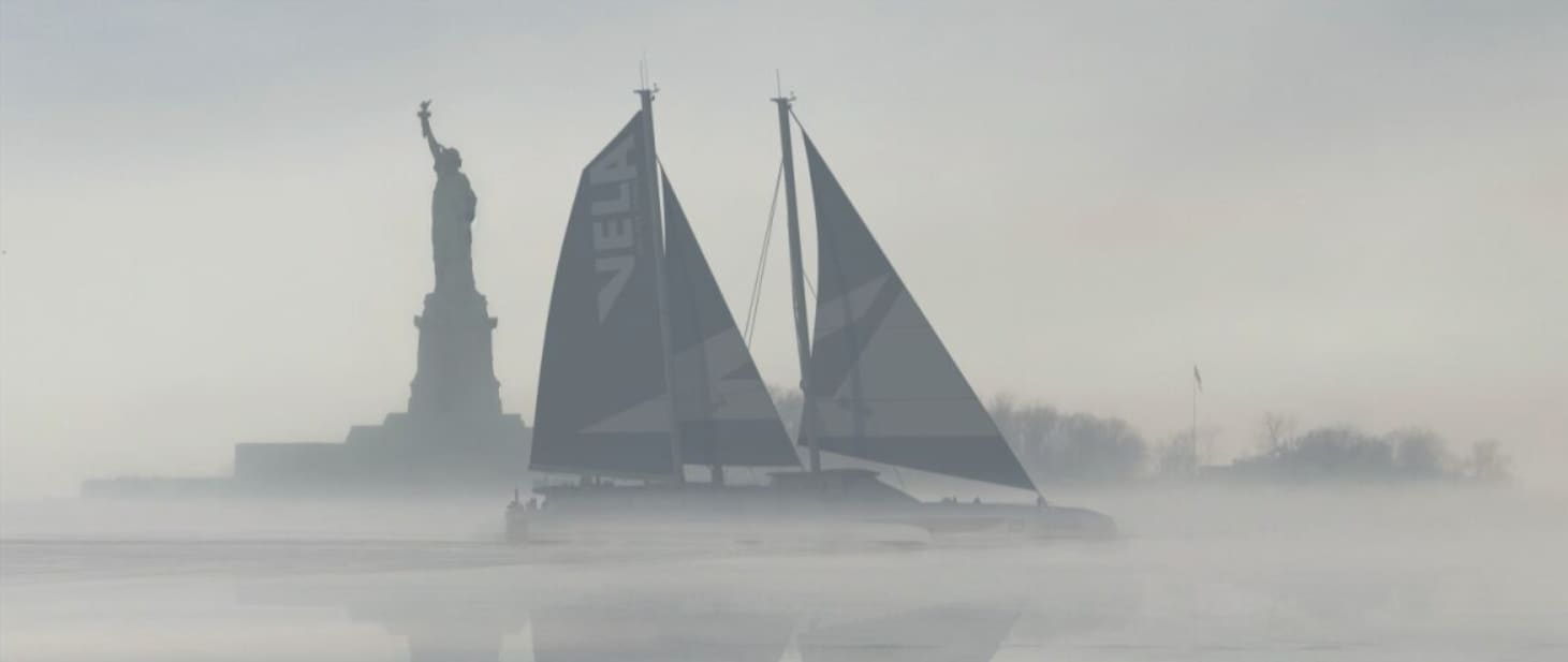 Sailboat with dark sails in misty waters near the Statue of Liberty.