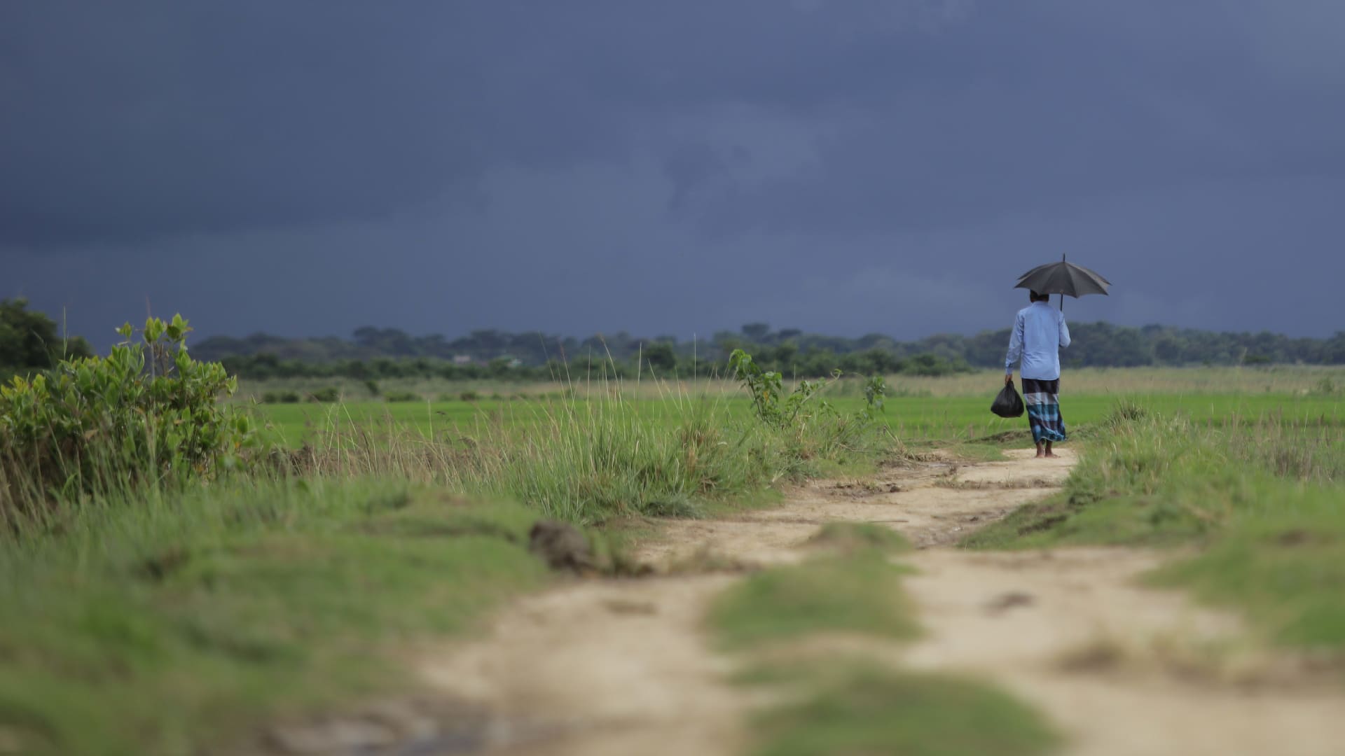 A person walking alone on cloudy day