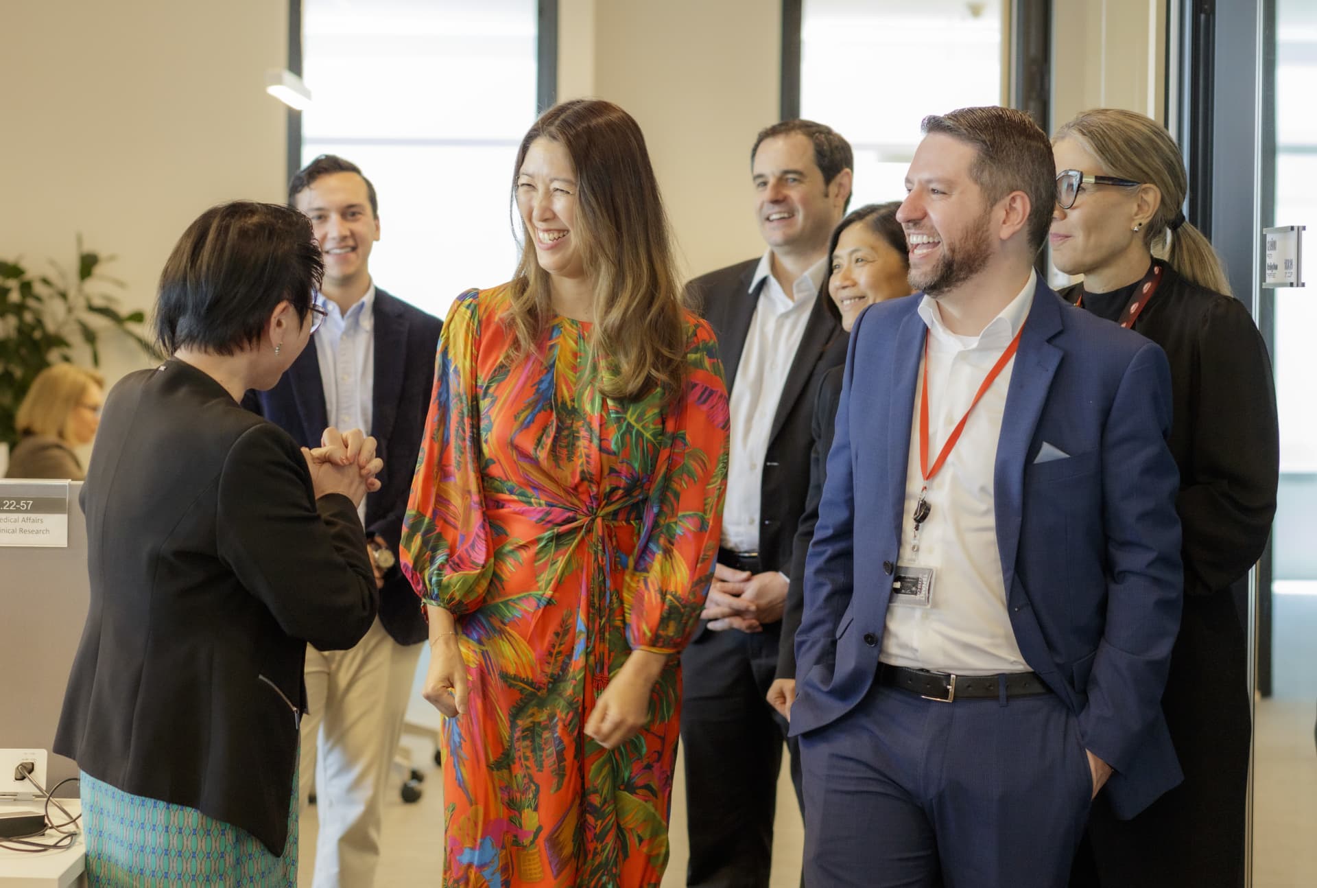 Julie Kim walking in office with group of people.