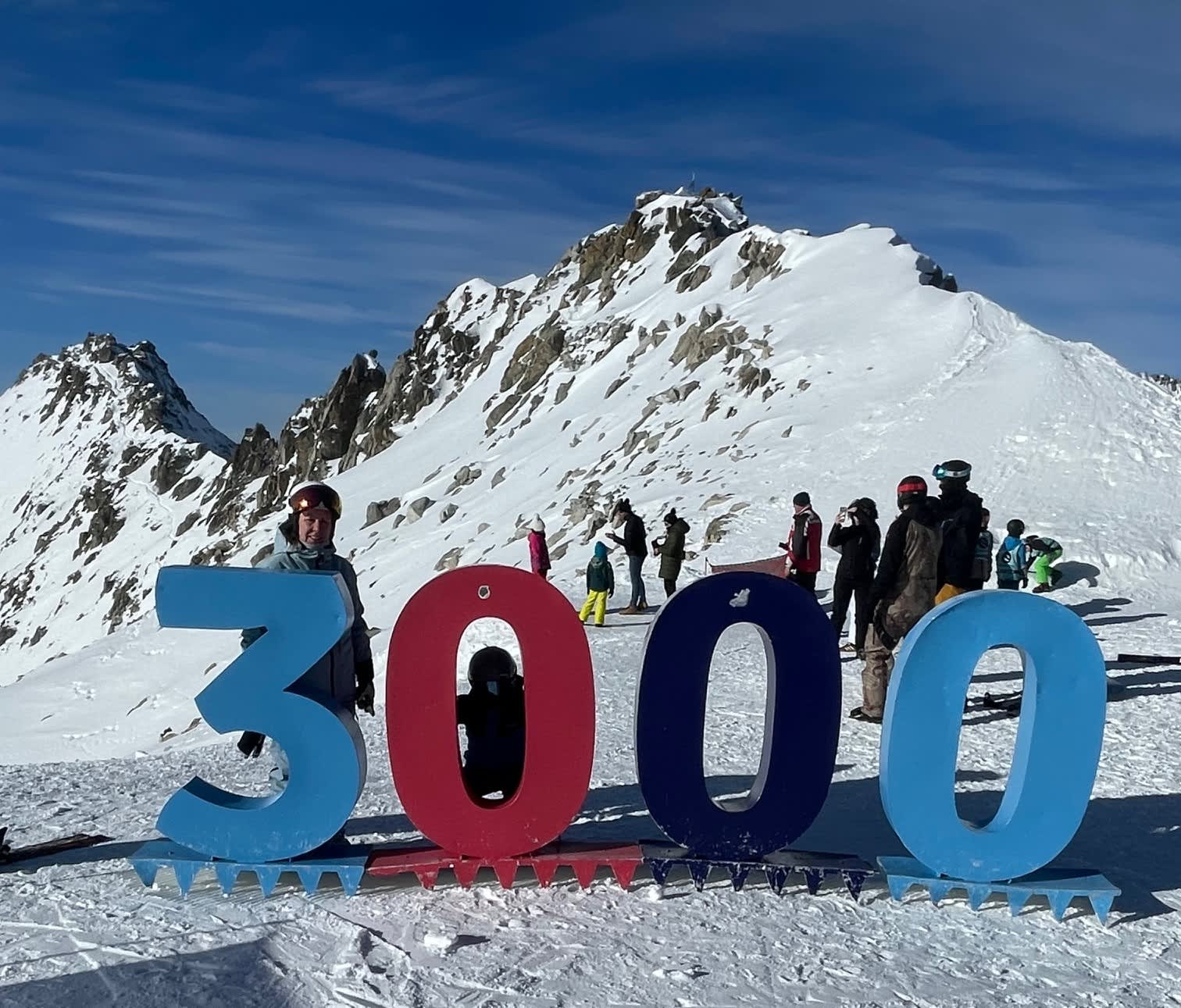 Photograph in snowy mountain with people and a large structure of numbers