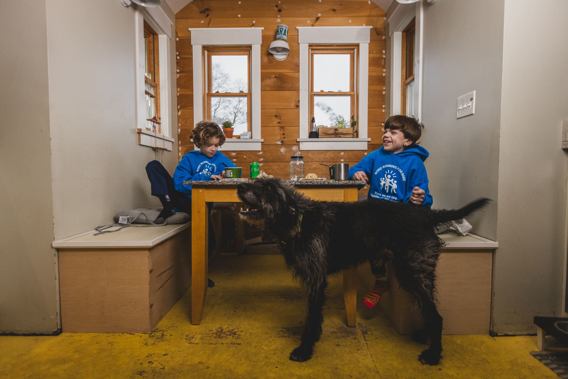 Two boys sitting at a table with a dog