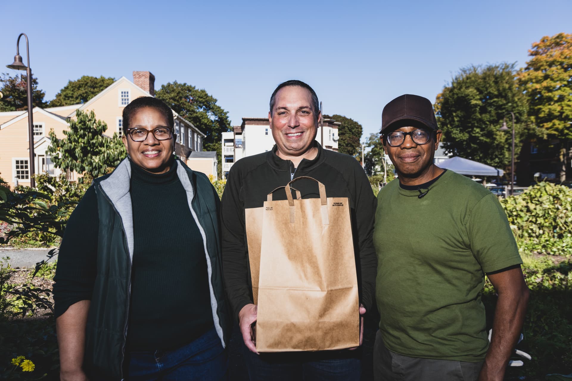 Patricia Spence, president and CEO of Urban Farming Institute (UFI), Chris Barr, US head of corporate social responsibility and philanthropy at Takeda, and Apolo Cátala, UFI program graduate, pose at the farm stand.