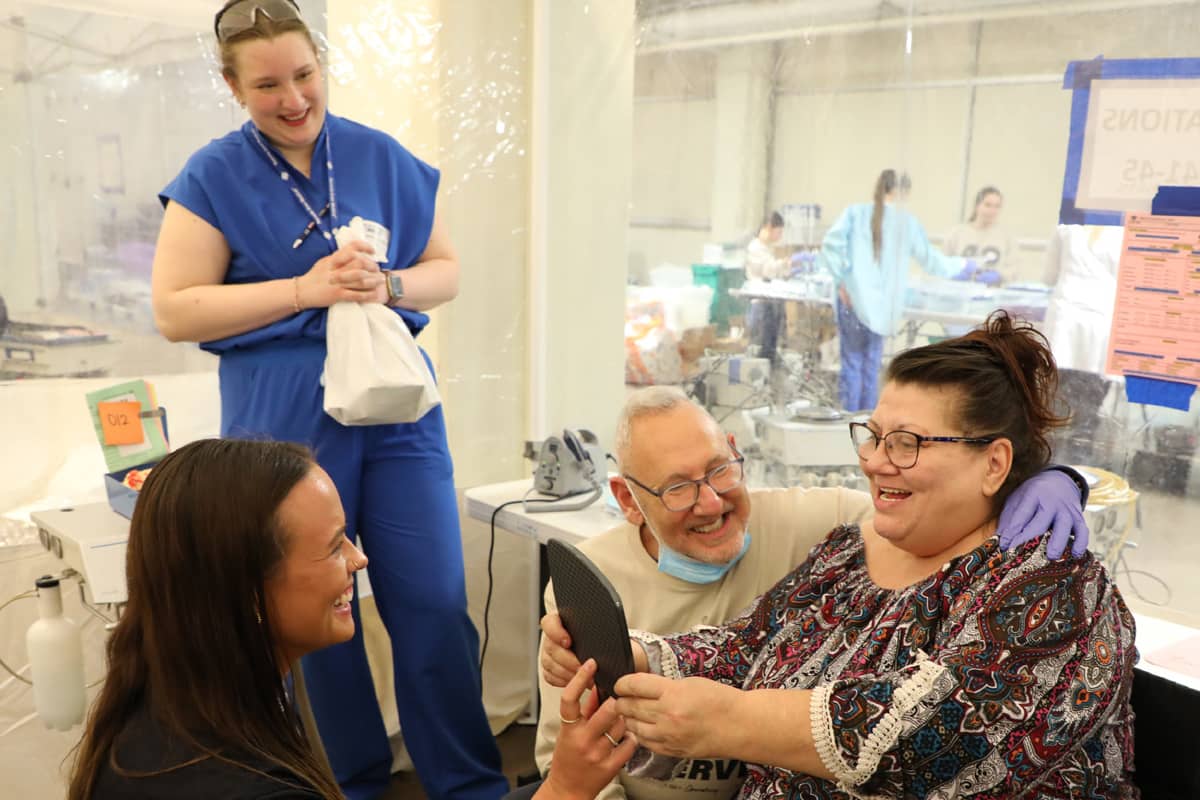 A woman receives a new pair of glasses at a Remote Area Medical clinic providing free vision, dental and health care.