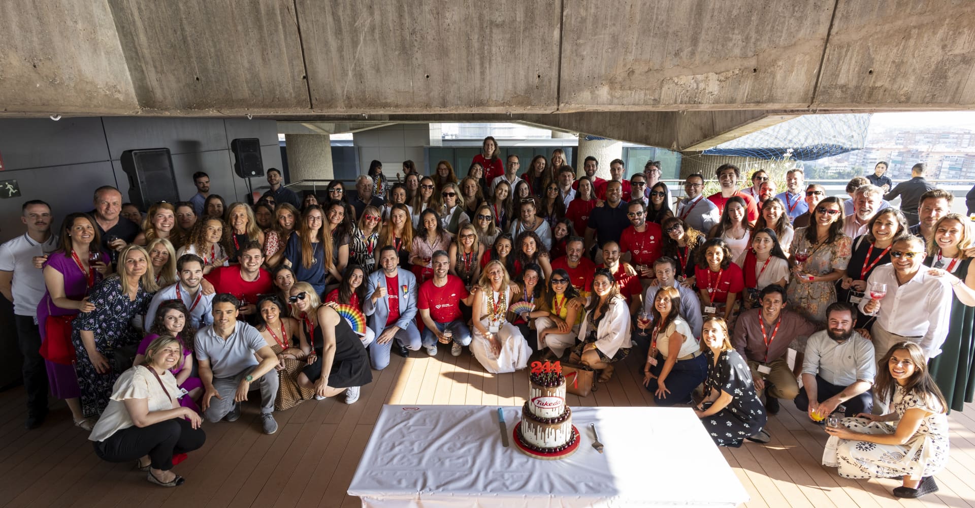 People posing for picture around a cake
