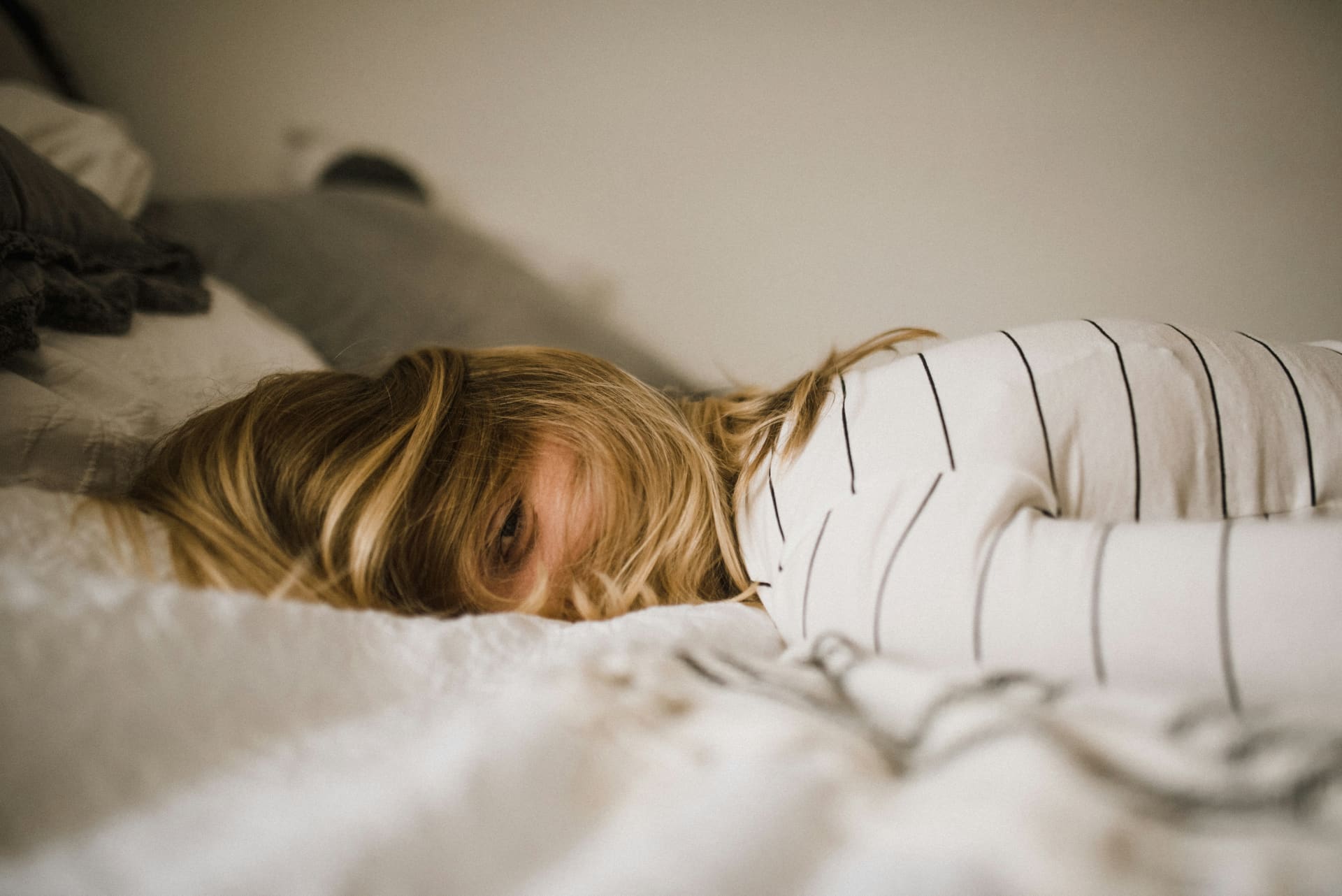 Woman lying face down on a bed