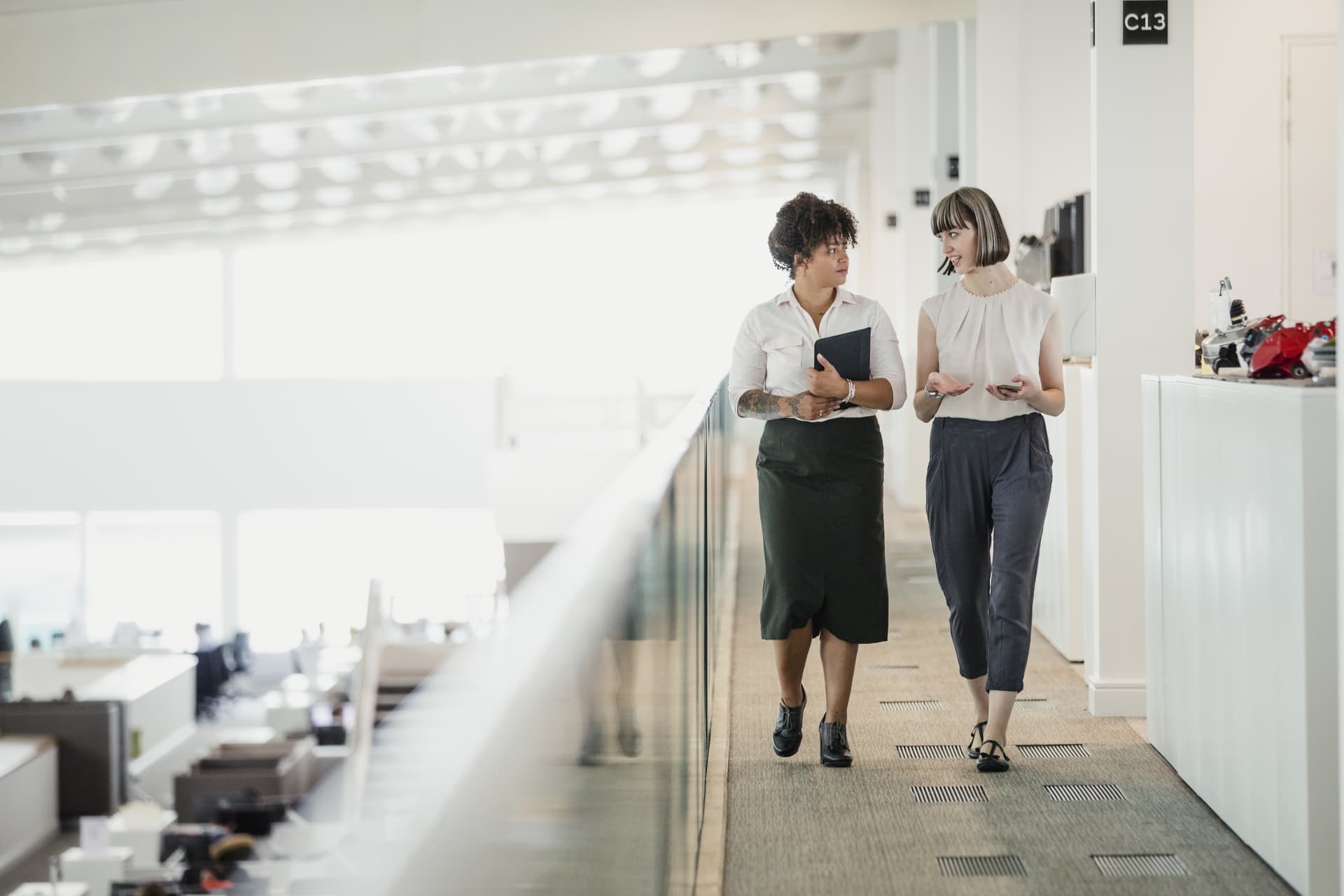 Two women walking on a long corridor