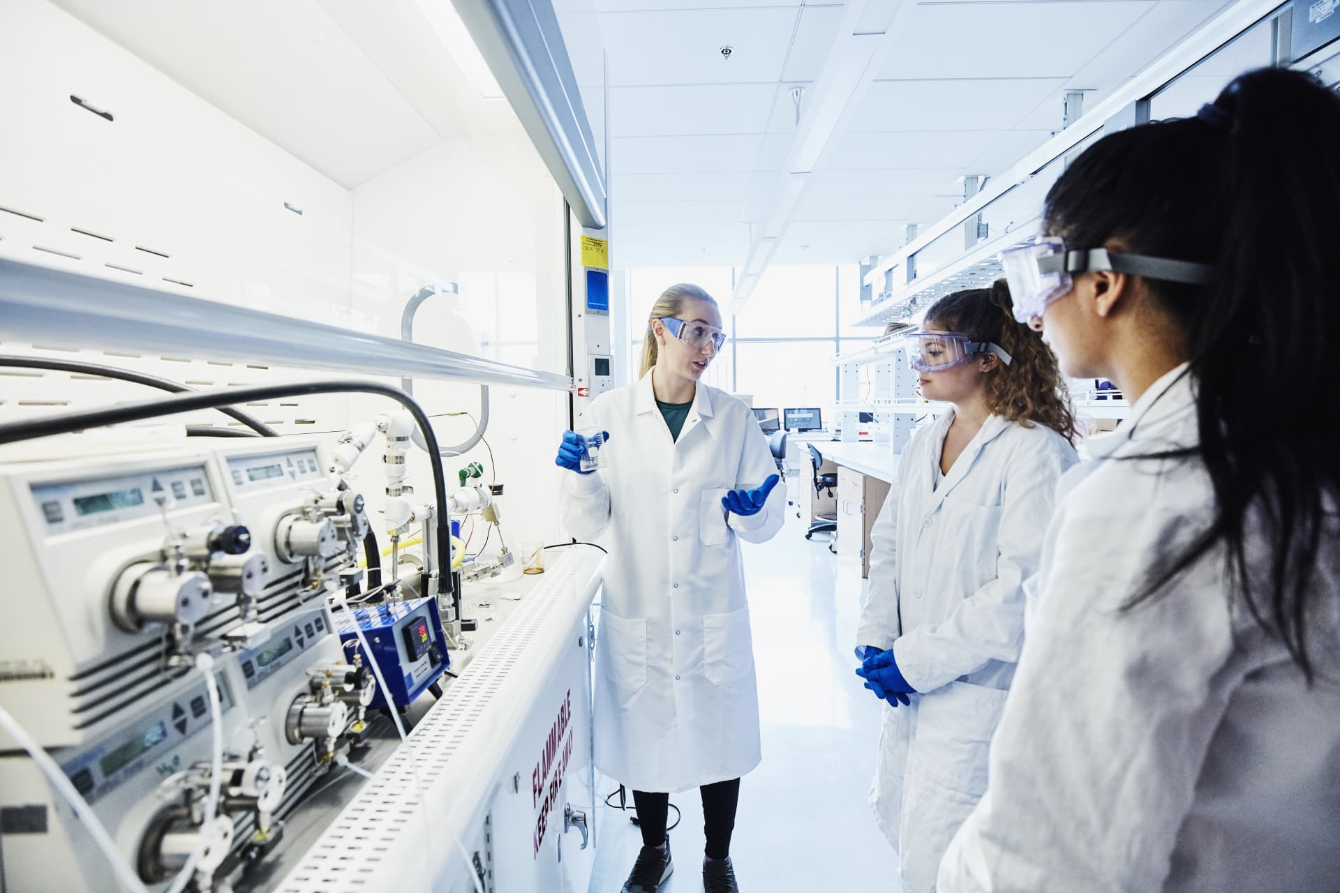 A group of people in white coats in a lab