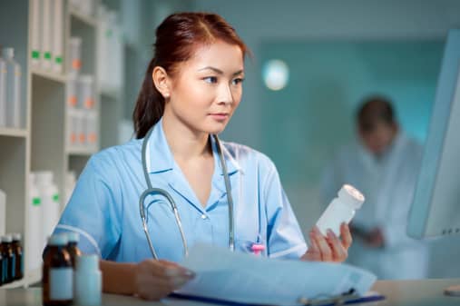 A nurse holding a bottle of medicine