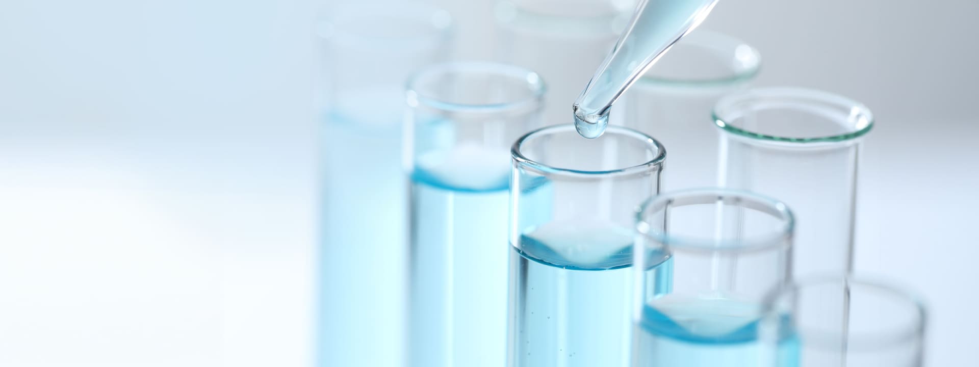 A pipette dropping liquid into a test tube