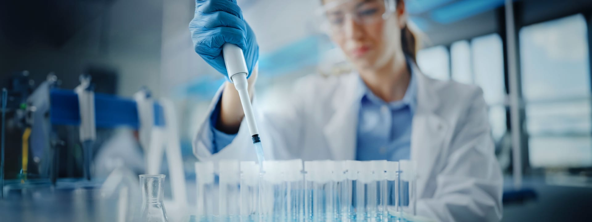 A person in a lab coat holding a pipette