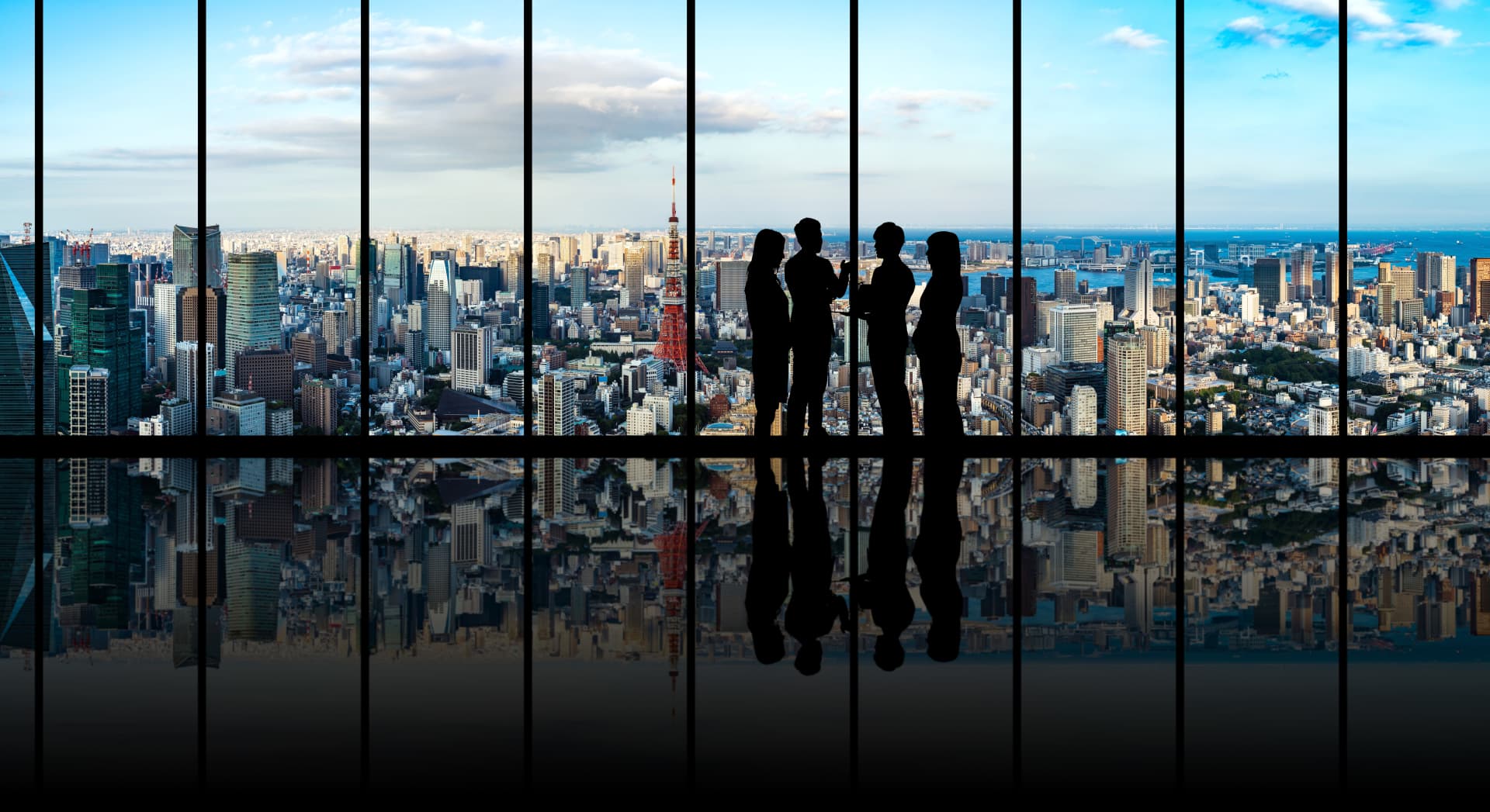 four people in front of a window with a view to a city skyline