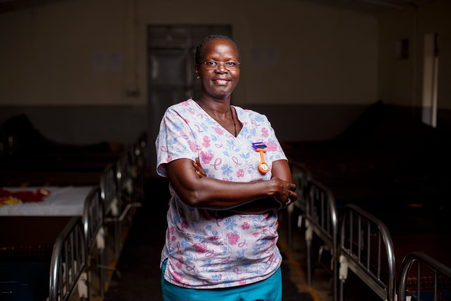 Photo of nurse with multiple hospital beds on the background