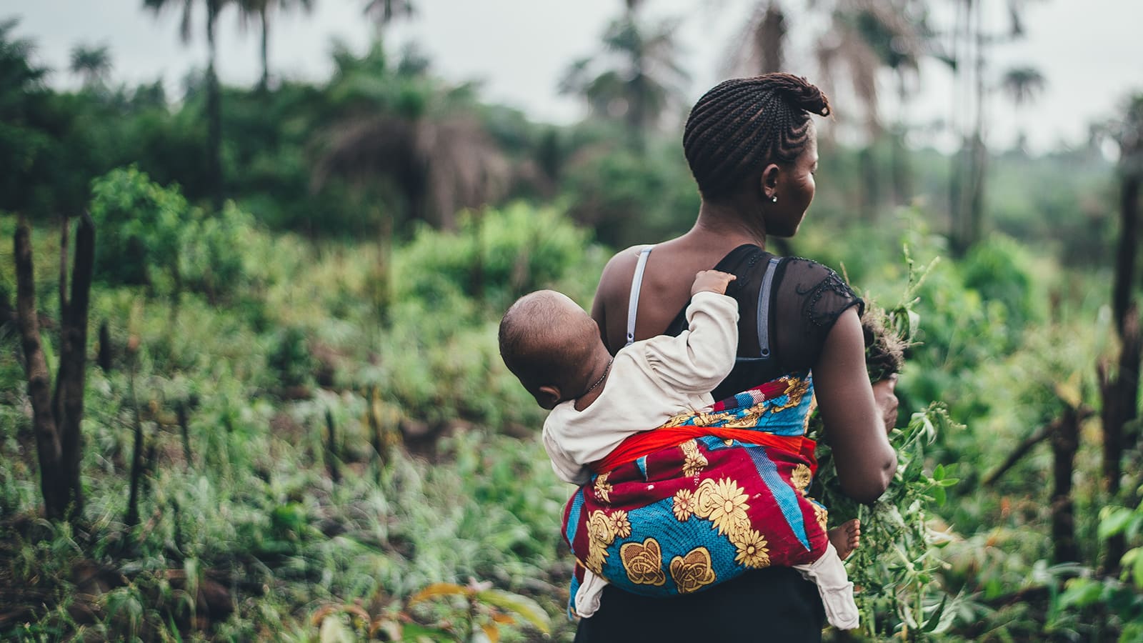 Mother carrying baby on her back.