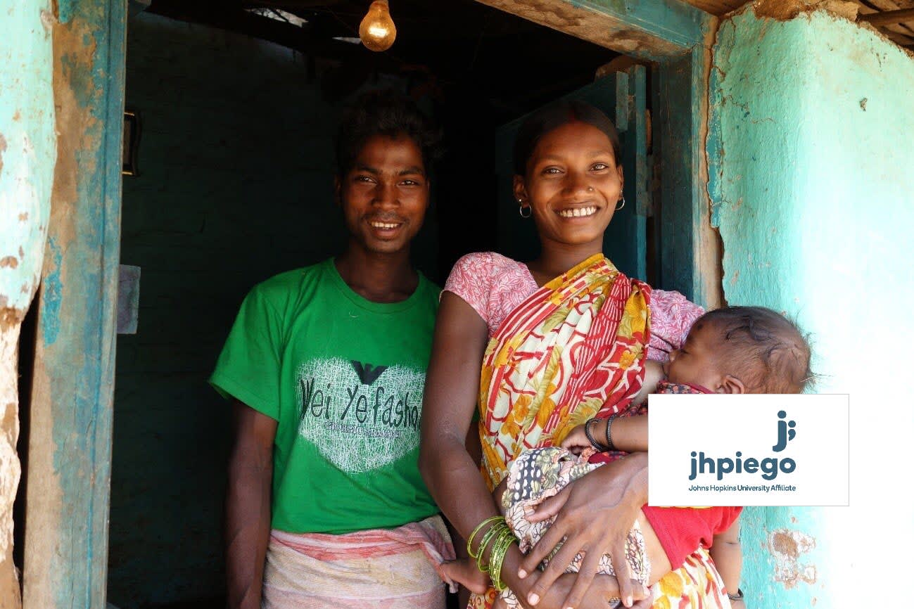 Parents smiling and carrying a child