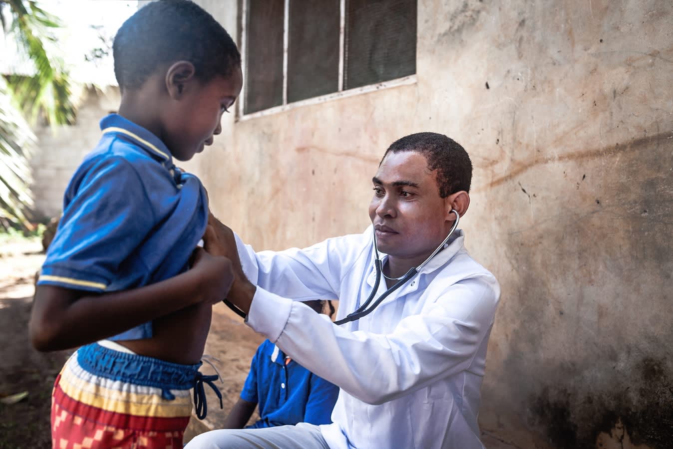 Physician listening to kid's heartbeat with stethoscope