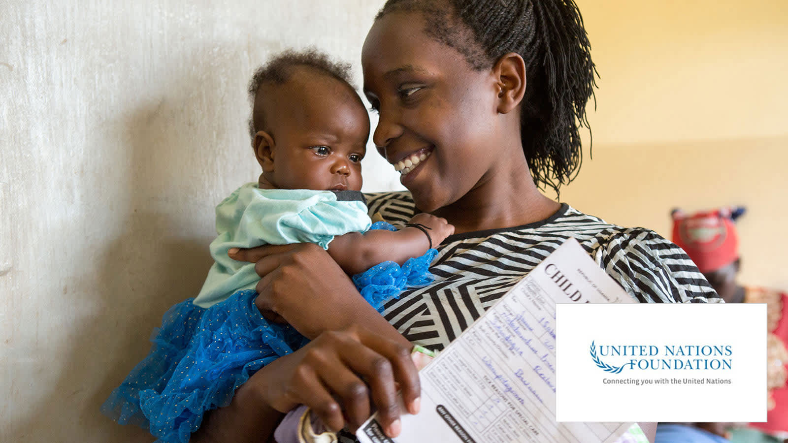 A woman holding a baby and a document