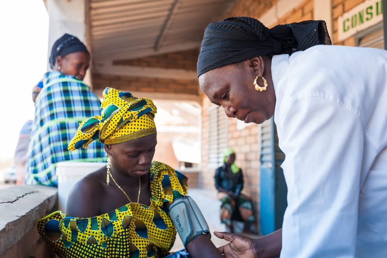 Physician taking pulse of woman