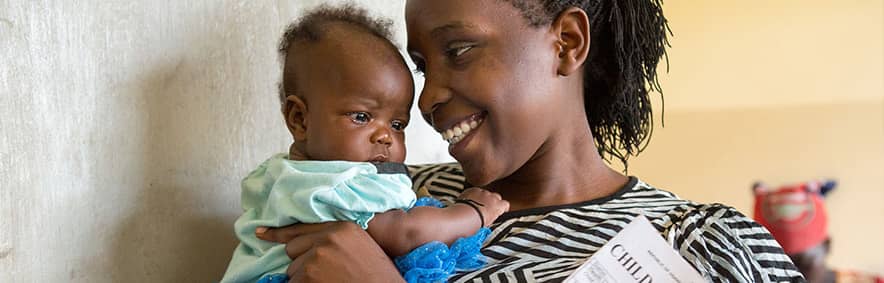 Woman carrying baby and child health card