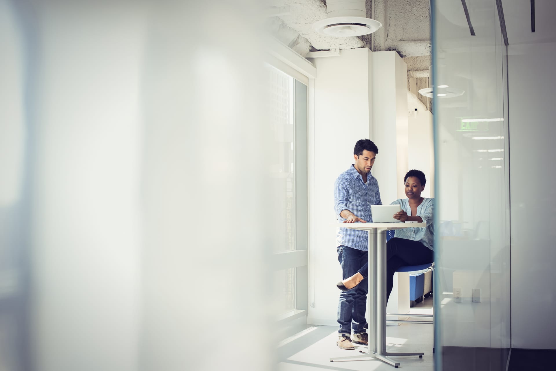 Two people talking seeing tablet