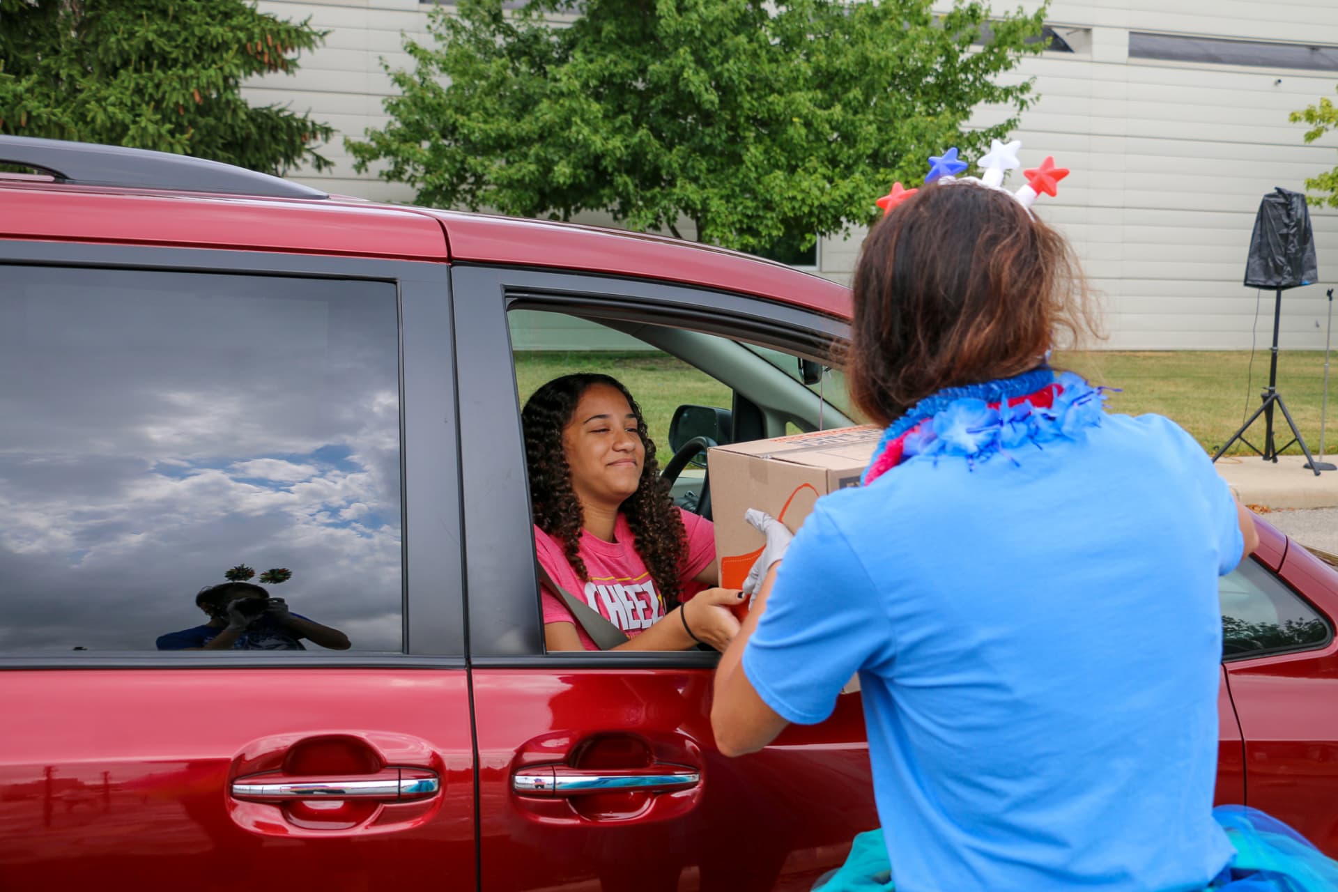 Woman delivering box to woman in van