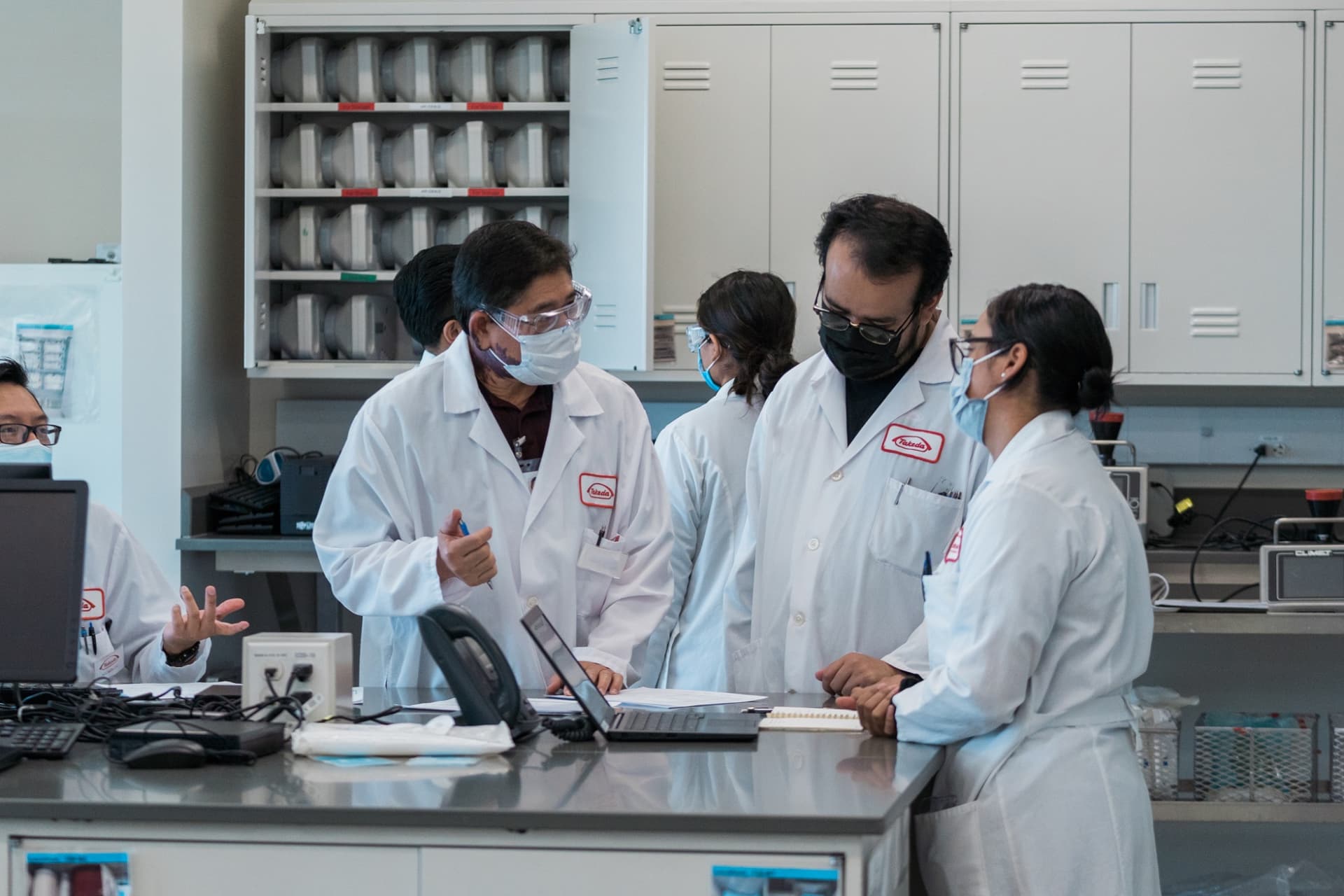 Three people in a lab discussing results