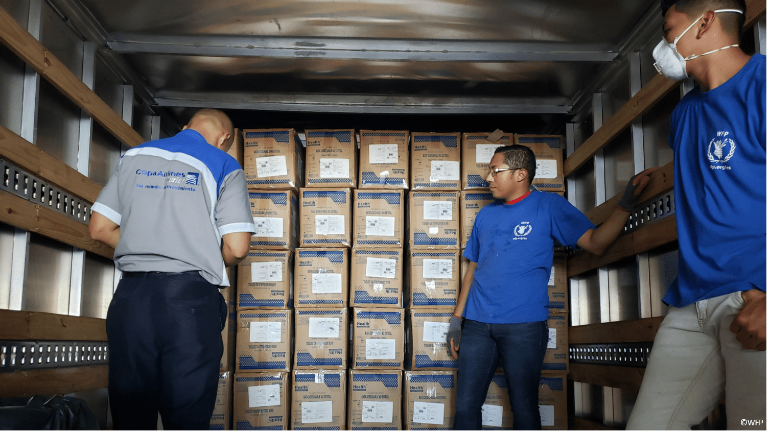 three men in a truck with boxes