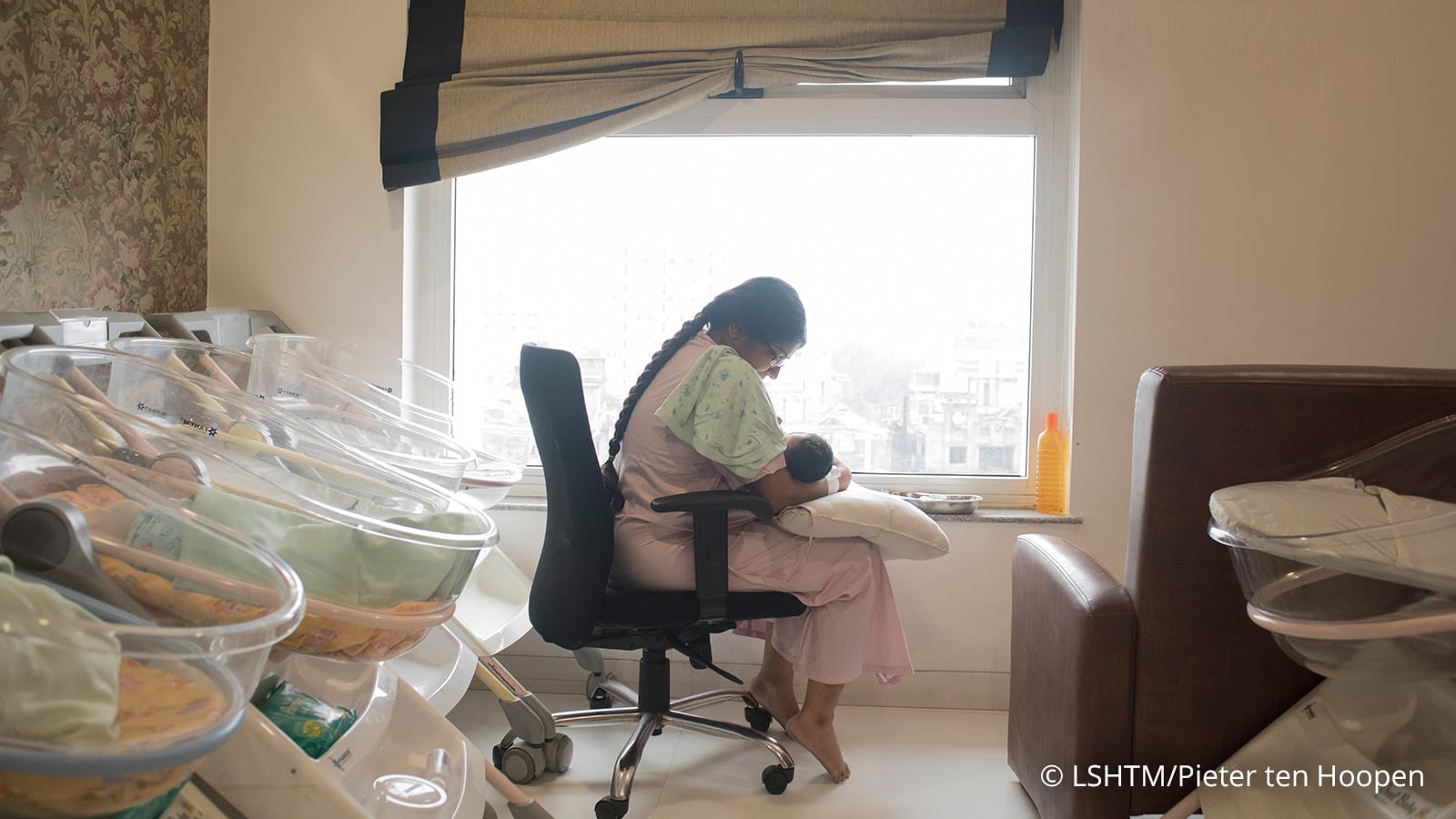 a woman carrying a baby in the nursery