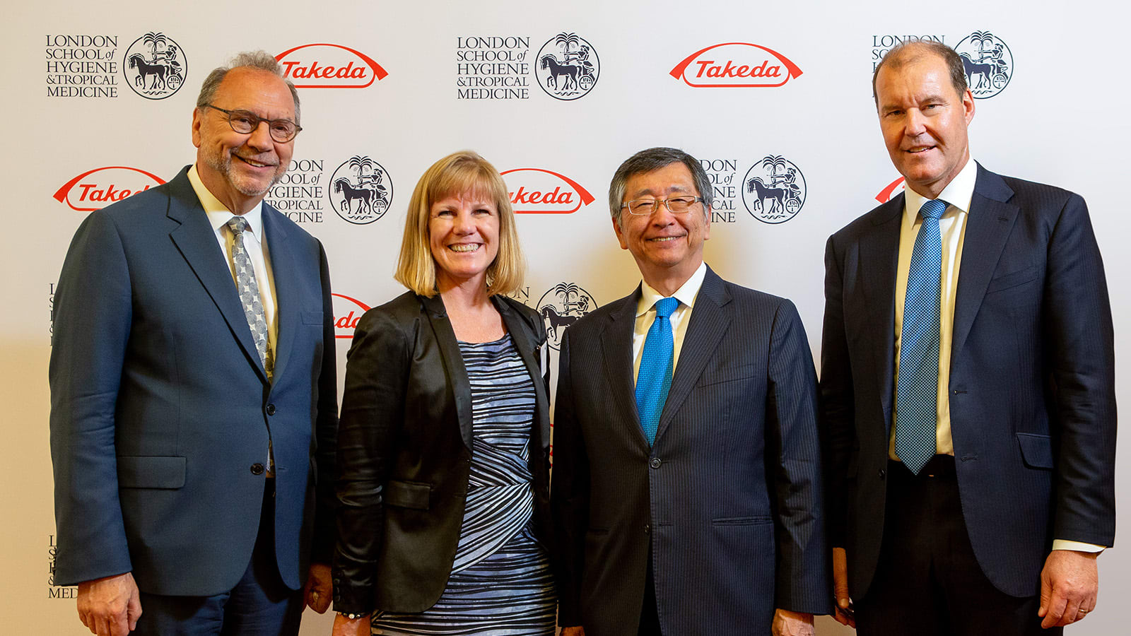 four people posing and smiling