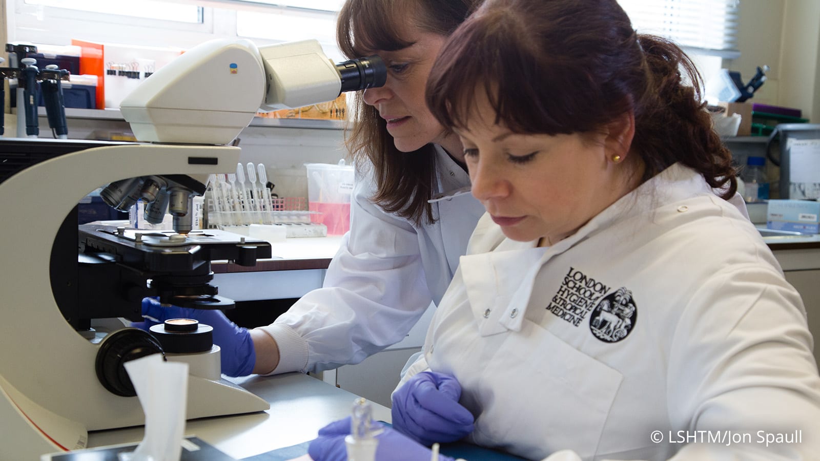 lab worker in front of microscope