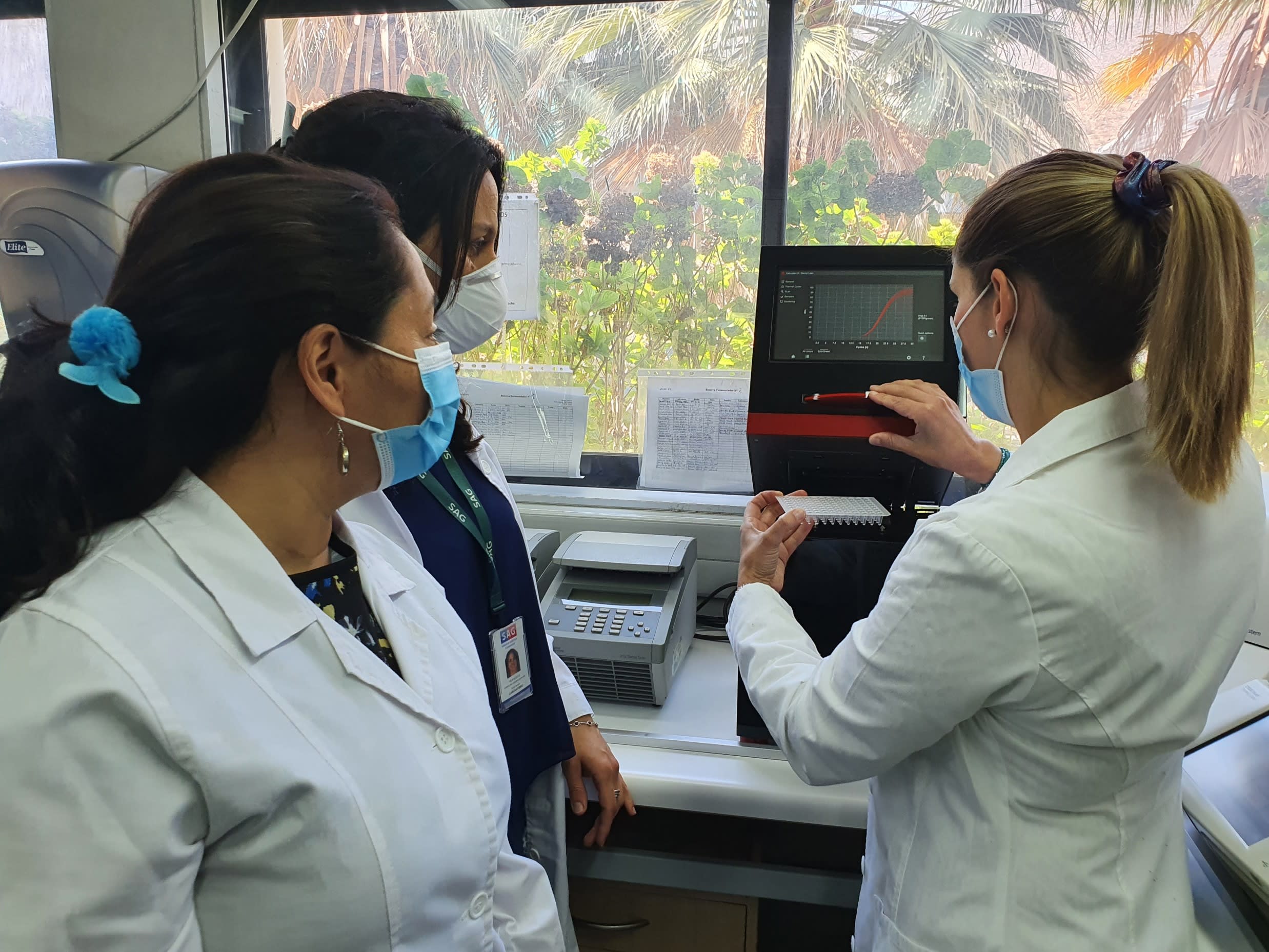 three physicians checking results in a lab