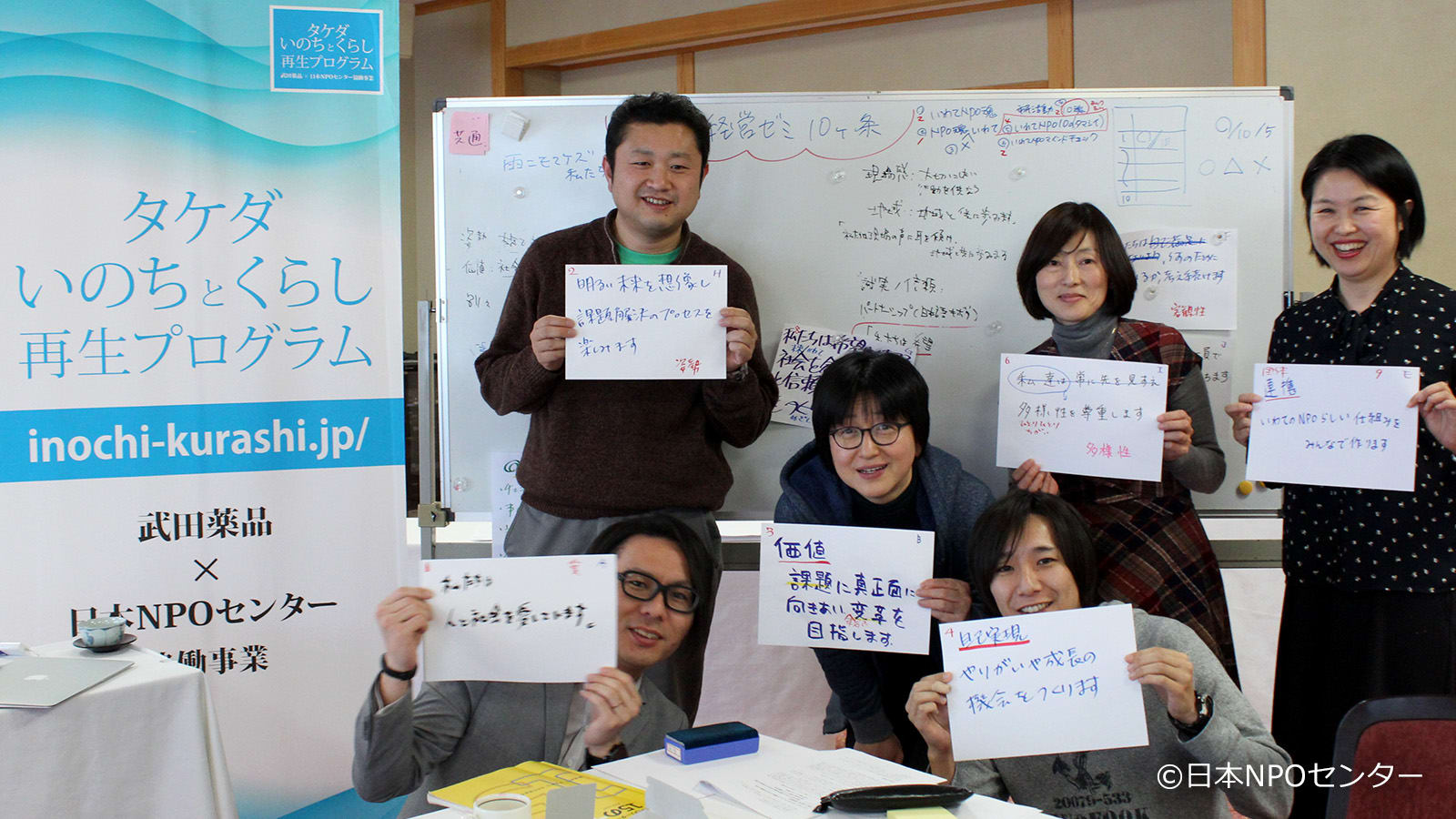 six people showing handwritten signs in a classroom
