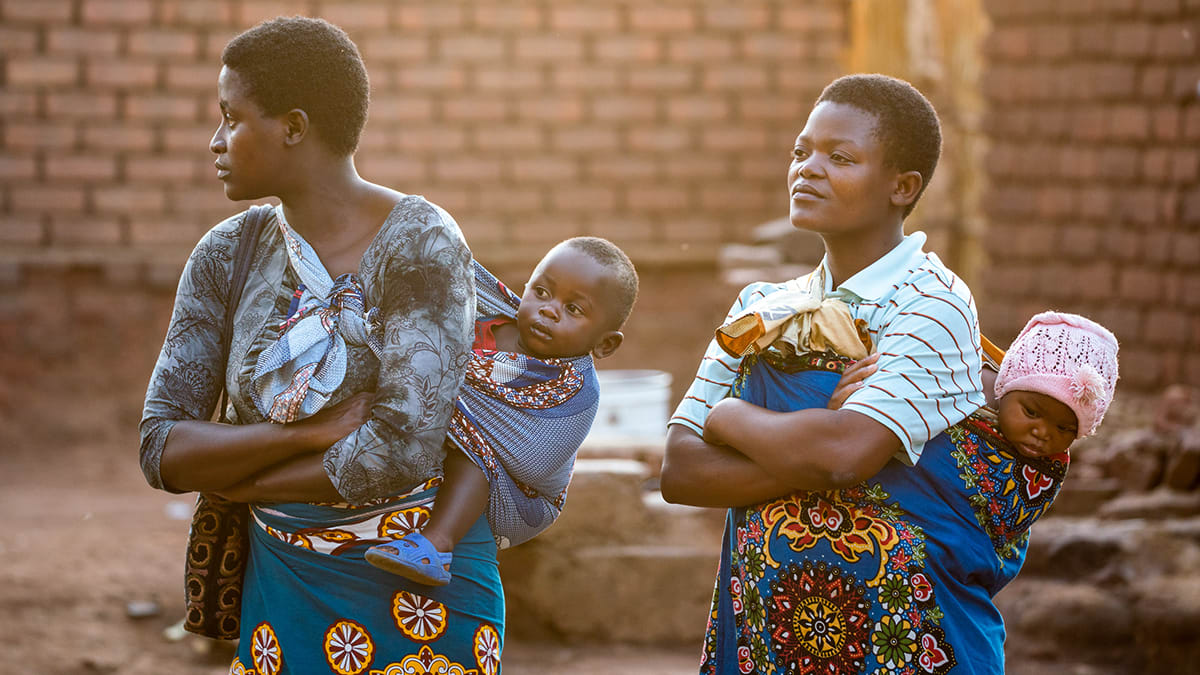 two mothers carrying their babies