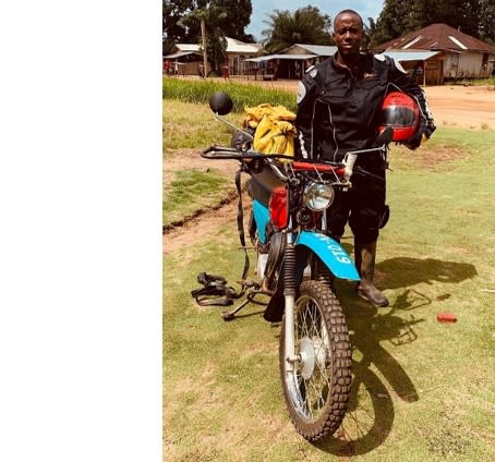 William Tamba next to his motorcycle