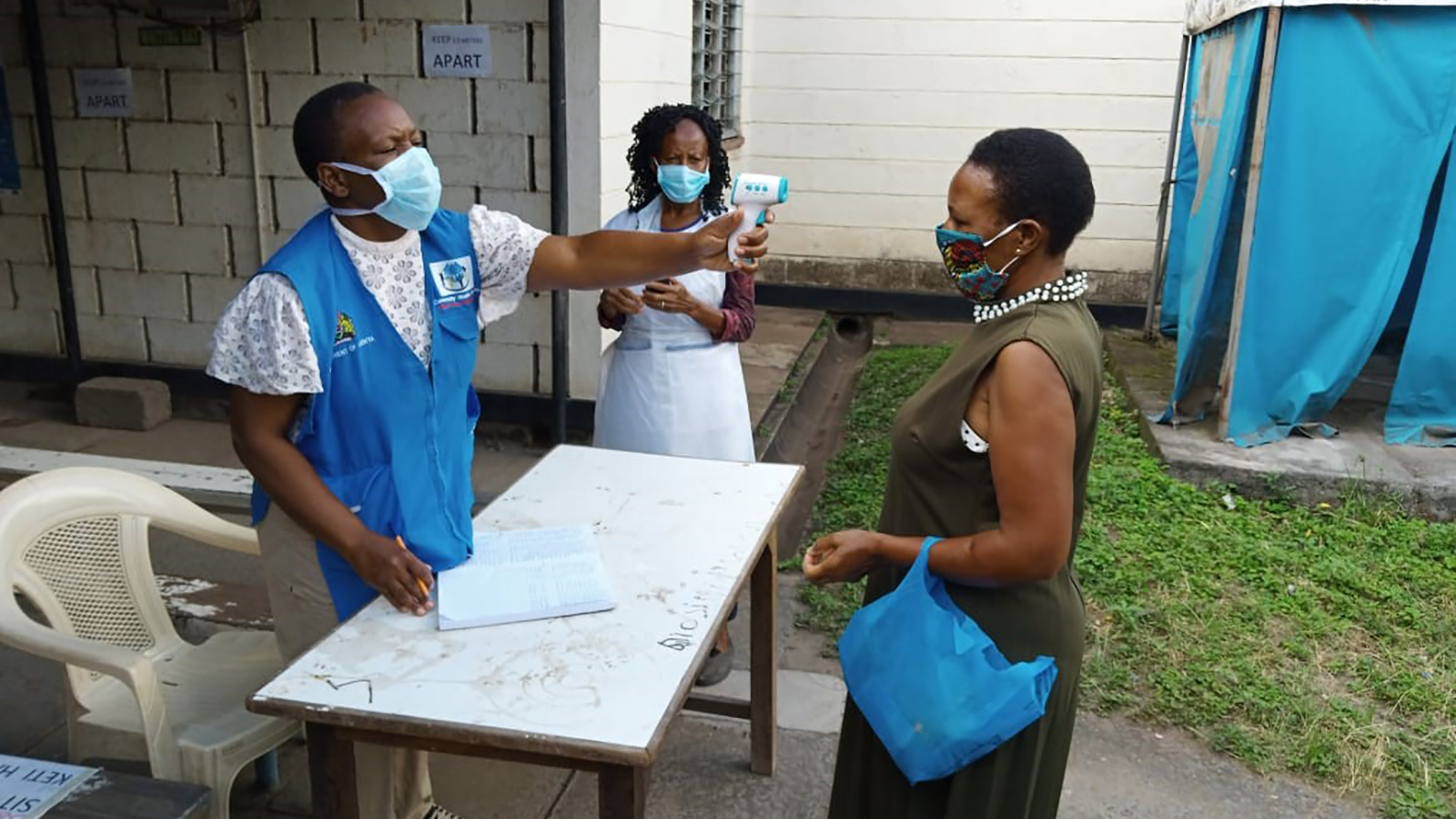 Community health volunteer taking temperatures at health facility in Nairobi.